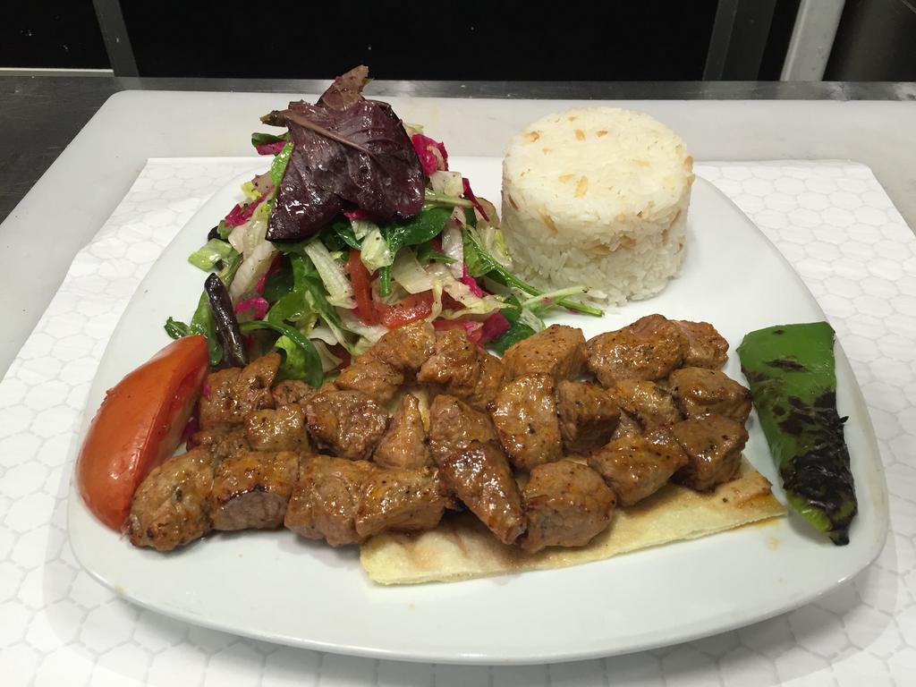 Diced Shish Kebab · Small cubes of baby lamb marinated in chef's special sauce and grilled on skewers. Served with rice and salad.