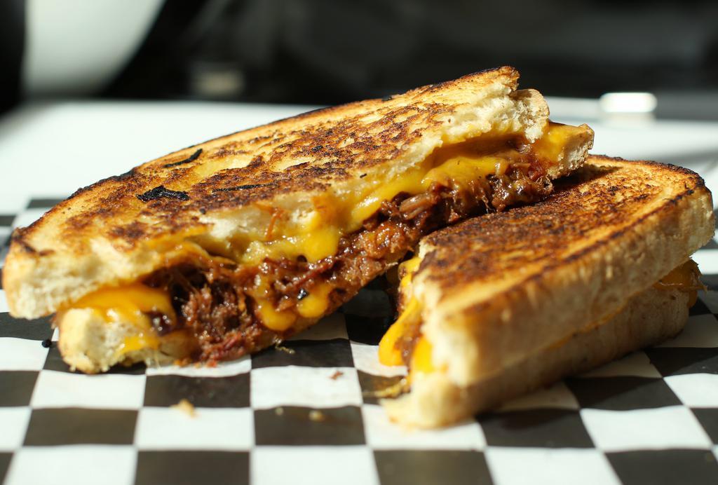 The Boss Sandwich · Slow-cooked BBQ brisket with melted sharp cheddar cheese grilled on sourdough bread.