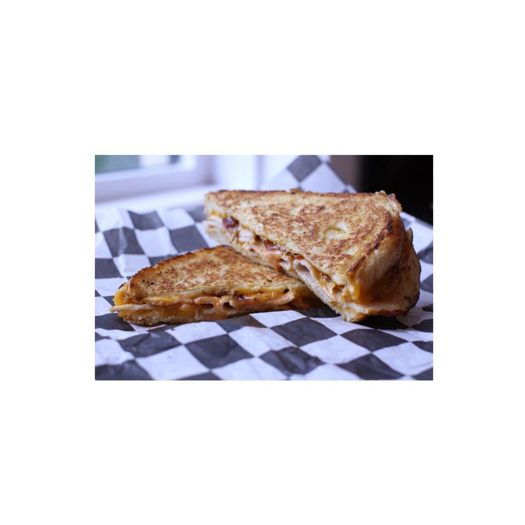 Turkey Trot Sandwich · Smoked sliced turkey, crispy bacon, house-made slob sauce and melted sharp cheddar cheese grilled on sourdough bread.