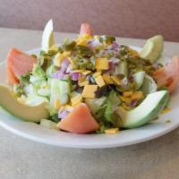 Mexican Salad · Avocado, jalapeno peppers, red onions, plum tomatoes and spicy cheddar cheese over mixed gre...