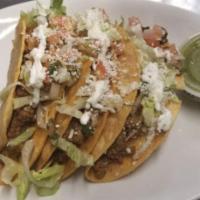 Hard shell tacos  · Crispy shells tacos, lettuce, tomato, sour cream and cotija cheese. Choice of shredded beef,...