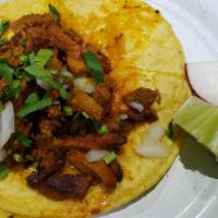 Al Pastor Taco · Marinated roast pork taco with cilantro & onions on soft corn tortillas. Salsa will be on th...