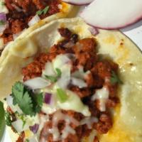 Taco Chorizo con Queso  · Mexican sausage, melted chihuahua cheese, onions and cilantro on corn tortillas. Salsa will ...