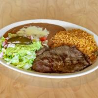 Carne Asada · Thin sliced steak served with refried beans. Served with rice, lettuce, onions, guacamole, r...
