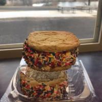 Sugar Cookie Sandwich · 2 pieces sugar cookie, vanilla ice cream, coated with rainbow jimmies.
