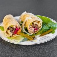 Shish Kafta · Ground meat with onion, tomato, pickles, and hummus wrapped in saji bread.