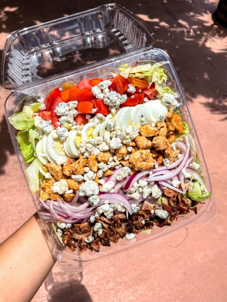 Cobb Chicken Salad · Bed of crisp lettuce, ripe tomato, sliced red onion, hard boiled egg, grilled chicken and bacon. Topped with shredded cheddar (no longer served with blue cheese). Served best with Ranch Dressing