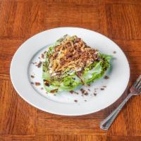Outrageous Wedge Salad · A crisp wedge of iceberg lettuce topped with homemade blue cheese dressing, crumbled Gorgonz...