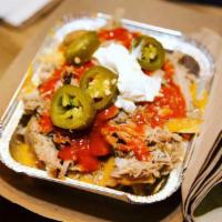 Ballpark Nachos -pork carnitas · Tortilla chips on a bed of pinto beans, topped with pork carnitas, nacho cheese sauce, sour ...