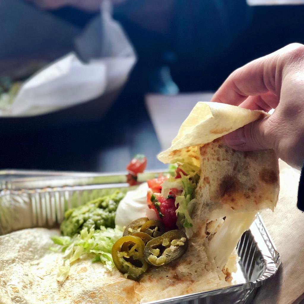 Quesadilla Grande -rice & bean topped w/guacamole · Large flour tortilla folded over rice, black or pinto beans and melted jack cheese; topped with lettuce, pico de gallo, sour cream, jalapenos and guacamole. (vegetarian)