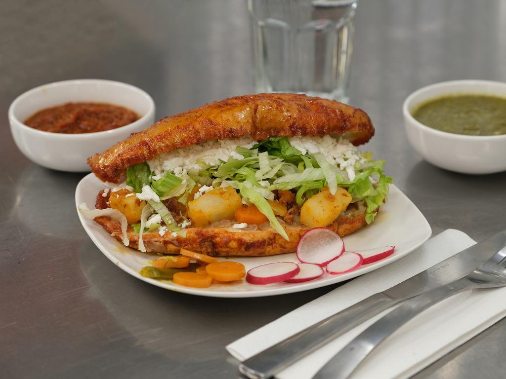 Pambazo Romeros Torta · Torta dipped in red chili sauce. Served with beans, potato, carrot, lettuce, sour cream, cheese, pickled jalapeno.