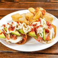 Huevos Ranchero · 2 sunny side eggs, crispy tortilla, avocado, pico de gallo, refried beans, queso fresco, and...