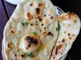 Crispy Garlic Naan · Flat white bread baked in tandoor oven with garlic.