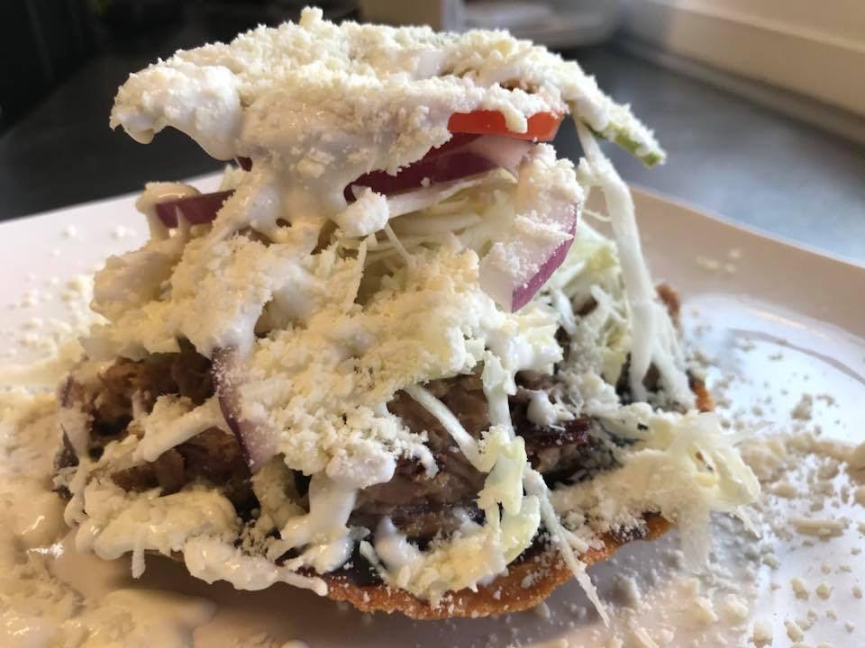 Carnitas Toastada · Pork roast. Fried corn tortilla with pork roast. Served with a mixture of cabbage, onion, tomato, radishes, avocado, sour cream and cotija cheese.