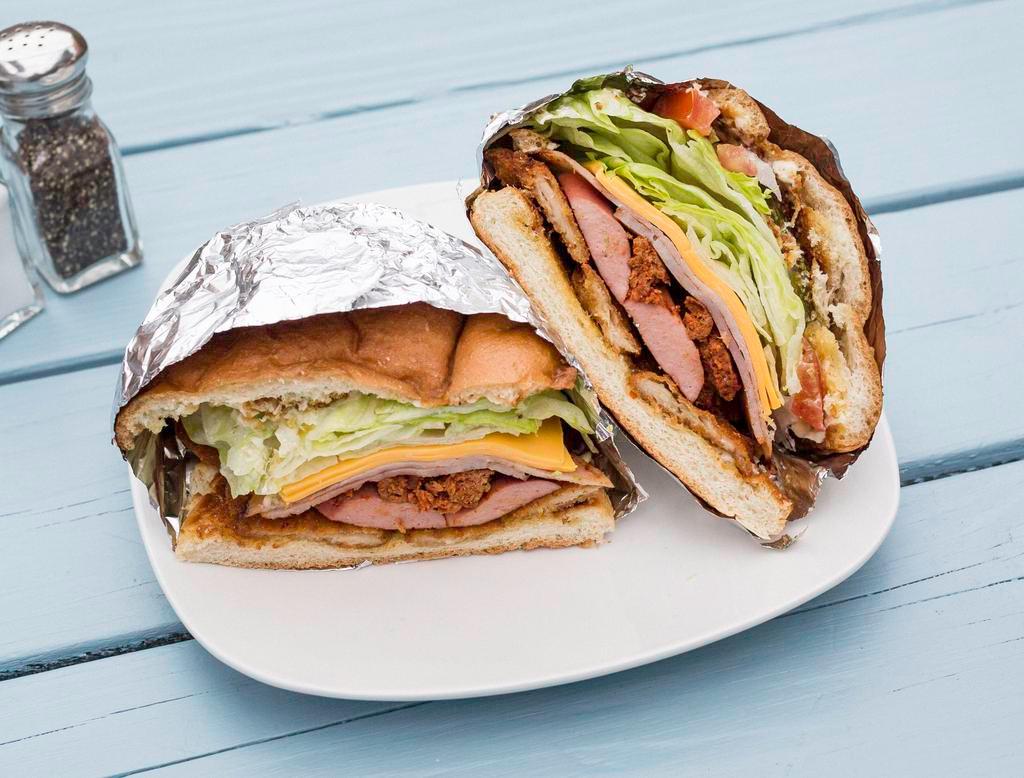Torta Cubana · Mexican bread with fried breaded steak,chorizo, (sausage) ham,hot dog, cheese, , lettuce, onion, tomato, avocado, peppers and vinegar.