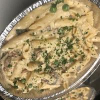 Penne Valli · Penne pasta sautéed with pancetta, onions, mushrooms, and peas in a cream sauce.