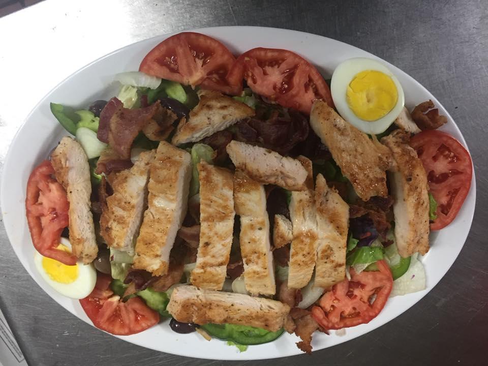 Cobb Salad · Lettuce, tomato, cucumber, green pepper, black olives, hard boiled egg and bacon topped with grilled chicken breast. Served with choice of dressing.