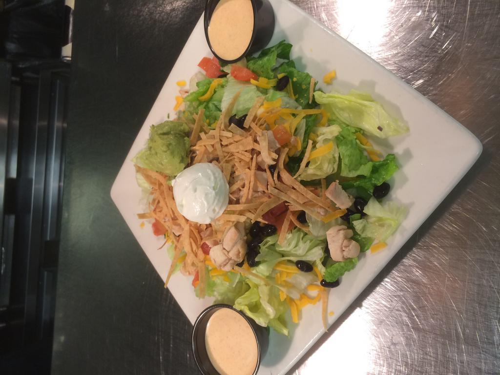 Southwest Salad · Grilled southwest marinated chicken on chilled mixed greens with black beans, cheddar cheese, diced tomatoes, and topped with crisp tortilla strips, sour cream, and guacamole. Served with chipotle dressing on the side.