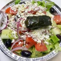 Horiatiki House Salad · Romaine lettuce, tomato, cucumber, red onion, stuffed grape leaves, feta and Kalamata olives.
