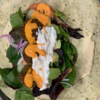 Falafel Wrap · On a spinach wrap hummus spread with Kale 🥬, spinach, onions, cucumbers 🥒, tomatoes 🍅, tz...