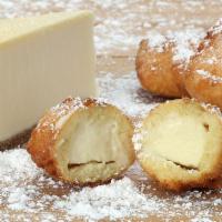 Deep-Fried Cheesecake Bites · 3 or 5 cheesecake bites dipped in funnel cake batter, fried, and coated in powdered sugar.