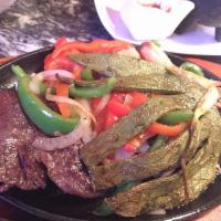 Entrana Rayada pero no de las Chivas · Grilled skirt steak with sauteed onions, peppers, mushrooms. Served with rice and beans.