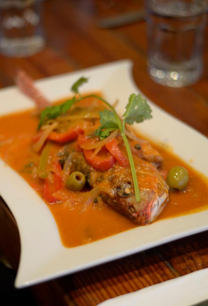 Branzino  · Whole Branzino cooked in light fresh tomato sauce with white wine, onions, peppers, olives and capers. Served with rice and beans.