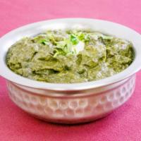 Punjabi Saag Paneer · Farmers cheese folded in our cumin, garlic flavored pureed spinach curry sauce. Served with ...