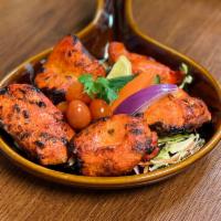 Chicken Tikka · Chicken breast marinated in yogurt and spices, cooked in tandoor and served over a bed of be...