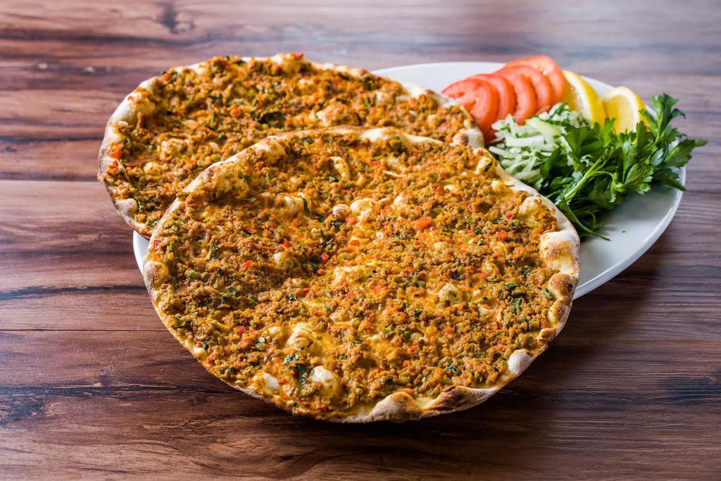 50. Lahmacun · 2 pieces.Anatolian version of ancient Turkish meat pie with ground lamb topped with parsley, fresh tomatoes, red peppers and onions all on thin dough.