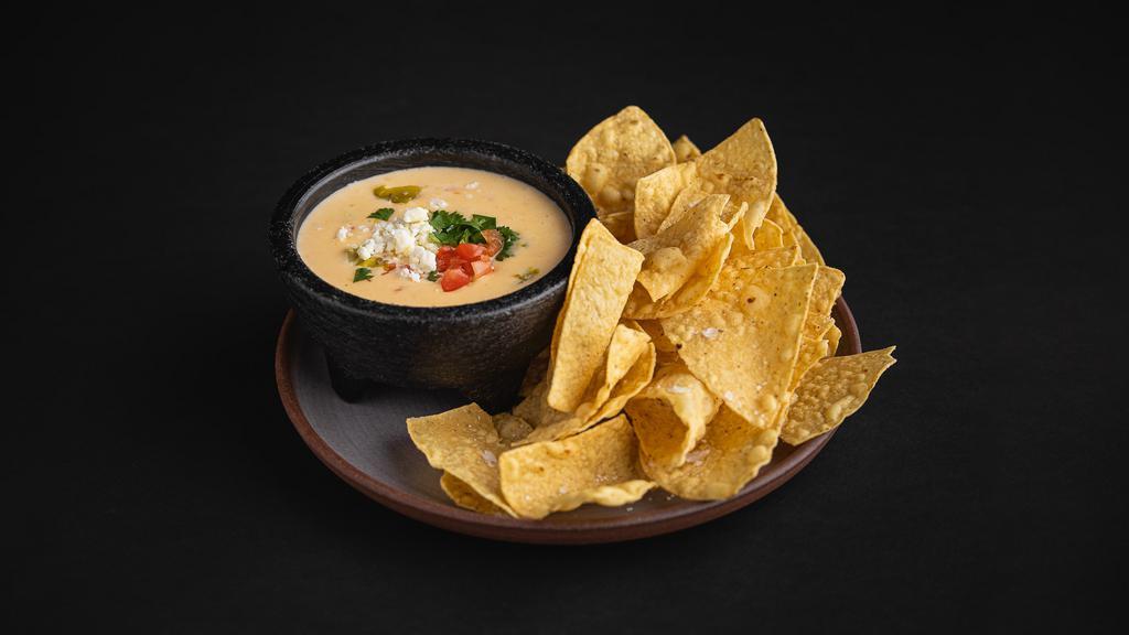 Chips and Queso · Bold, creamy, with just the right amount of kick – our hatch green chili queso is topped with Cotija and cilantro, and served with corn tortilla chips.