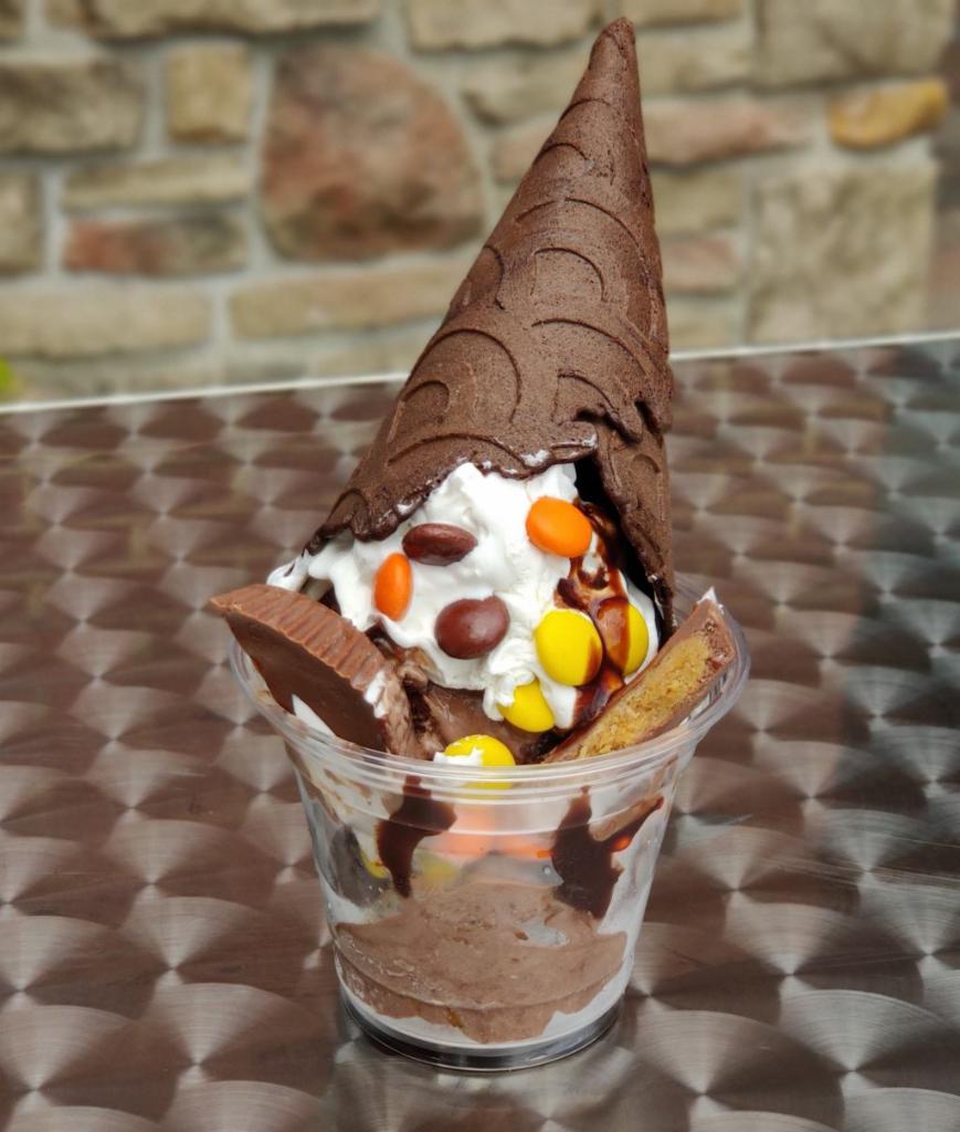 Poppin' Peanut Butter Sundae · Chocolate-peanut butter ice cream, hot fudge, Reese's pieces and peanut butter cups, whipped cream, and dark chocolate cone. 
