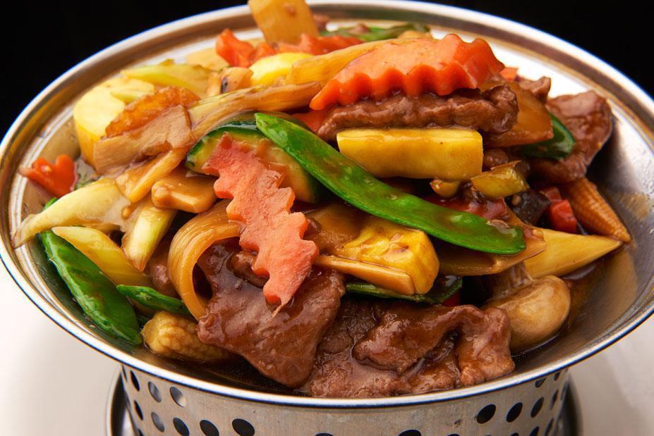Wok · Slices of chicken or beef with mixed vegetables in brown sauce served in a wok.