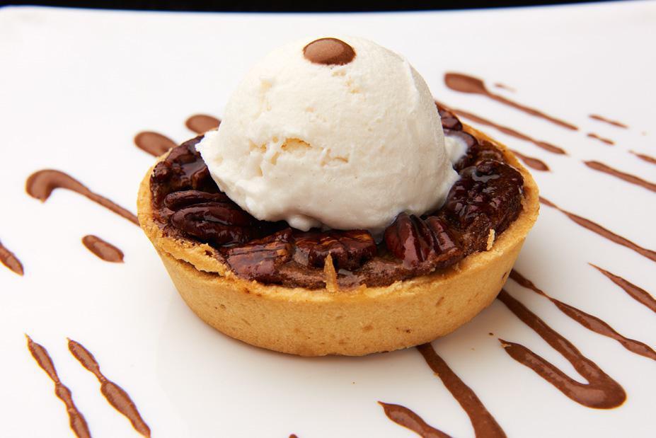 Chocolate Pecan Torte · Thin light crust topped off with roasted pecans in a caramel syrup and finished with divine chocolate. Served with vanilla ice cream. 