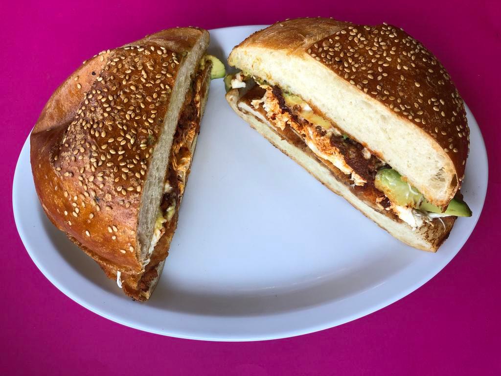 Cemita Milanesa de Res · Breaded steak. Puebla style sandwich. Seasame roll with refried beans, onions, avocado,  papalo, chipotle, Oaxaca cheese, and mayonnaise.
