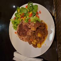 Curry Goat · Braised goat stewed slowly in spicy curry gravy. Served with your choice of rice, salad or s...