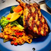 Pork Chop · Served with mamposteado rice and sauteed vegetables in garlic.
