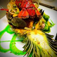 Mariscada al Ajillo · Served in 1/2 a pineapple with lobster, shrimp, mussels, clams, calamari, salmon, and tilapi...