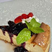 Cheese Cake · Homemade cheesecake with assorted berries and whipped cream.