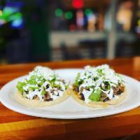 Sope · 2 corn patties topped with beans, crema queso fresco, lettuce, red sauce. Chicken, steak or ...