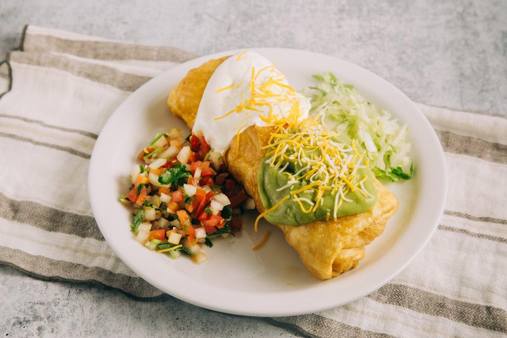 Chicken Chimichanga · Chicken deep fried burrito with beans, cheese inside and guacamole, sour cream and cheese on top.