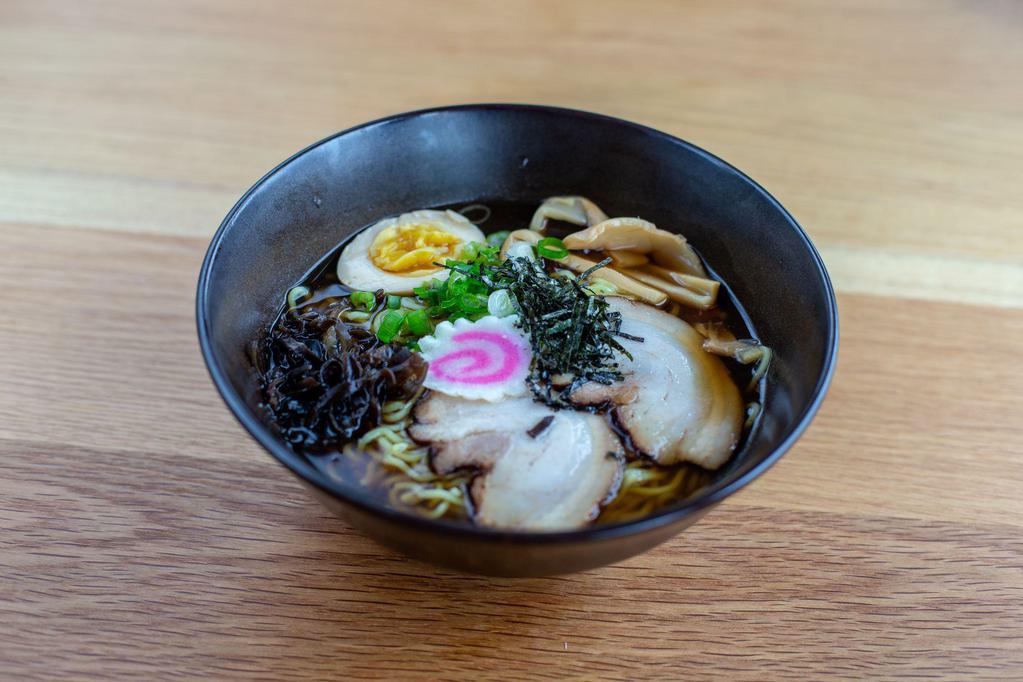 Shoyu Ramen Bowl · Wavy noodles in our special shoyu broth topped with braised pork belly, scallions, bamboo shoots, kikurage mushrooms, fish cake and half boiled egg.