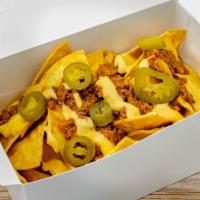 Nachos · Homemade chili (ground beef) served with cheddar cheese sauce, freshly made tortillas chips ...