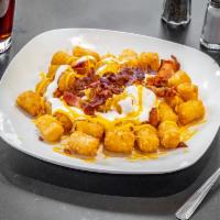Loaded Tater Tots · Crispy tater tots topped with melted cheese, bacon, and sour cream. 