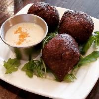 Kibbeh · Crispy bulgur wheat balls of ground beef, grilled onions, herbs, & spices. Served with homem...