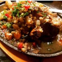 Lamb Shank · Braised flavorful cut of lamb topped off with roasted seasonal vegetables, bulgar wheat, & p...