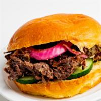 18 Hour Beef Sandwich · Served on a brioche bun with pickles, pickled & crispy onions, and slaw 