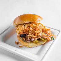 Pulled Chicken Sandwich · Served on a brioche bun with pickles, cabbage, pickled onions, crispy onions, and slaw.