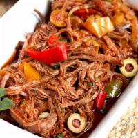 Ropa Vieja · Brisket cooked in tomato sauce with rice and beans.