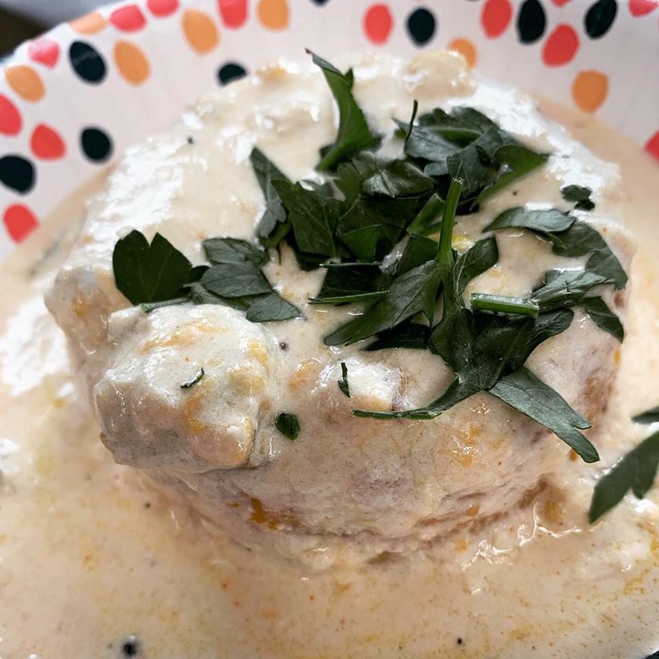 Commoner Cheddar Grits · A heaping portion of aged white cheddar polenta grits topped with a green pepper and corn bechamel with crabmeat and Gorgonzola cheese.